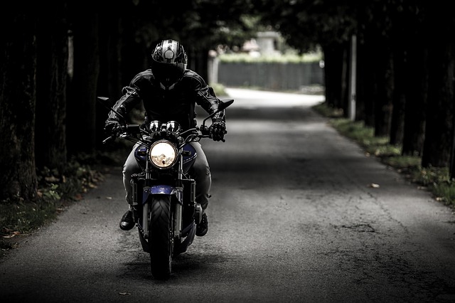 motorkář na cestě uprostřed lesa